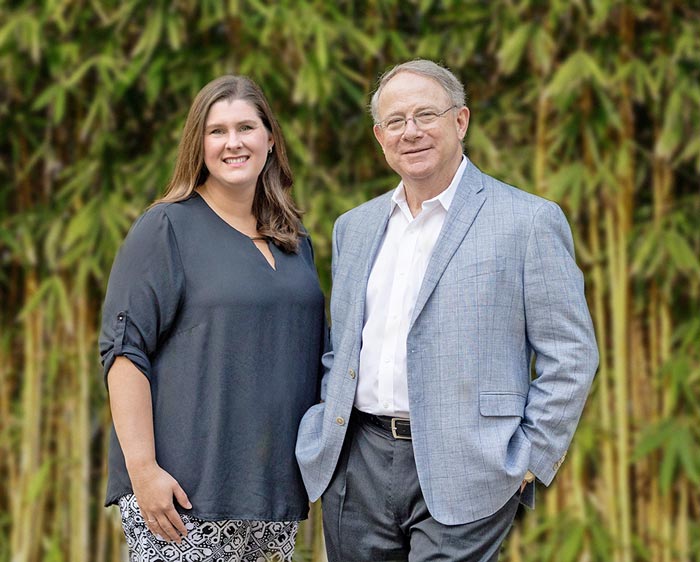 Photo of Dr Michael Ledet and Sara Welch with foliage behind them